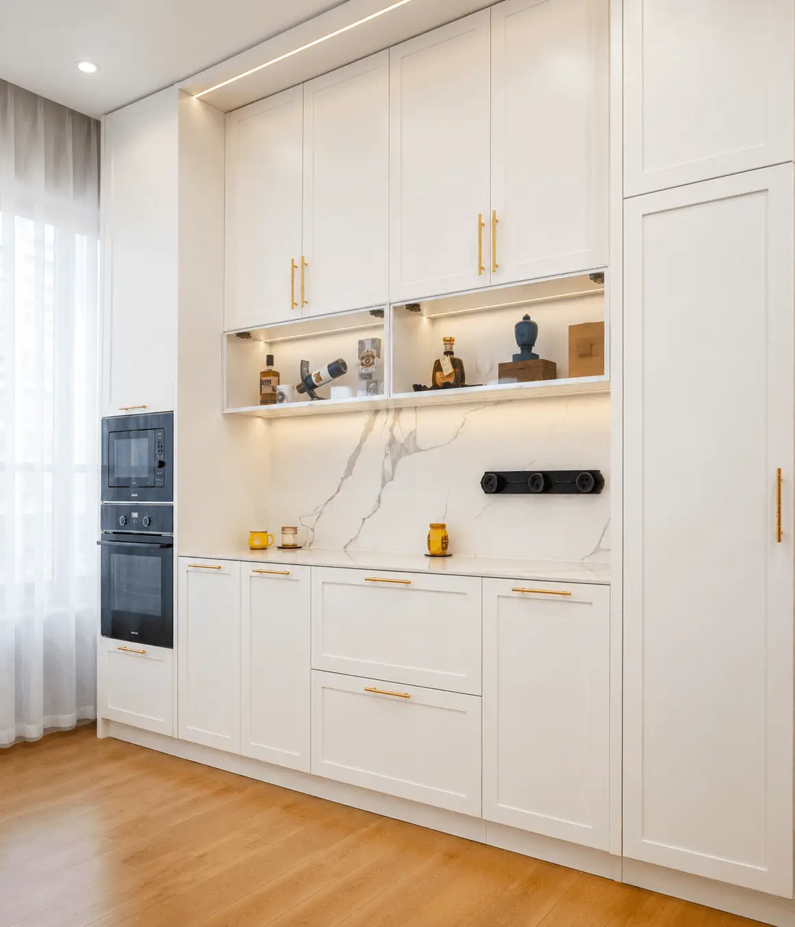 modern custom white kitchen cabinets with built-in oven, marble backsplash and LED lighting